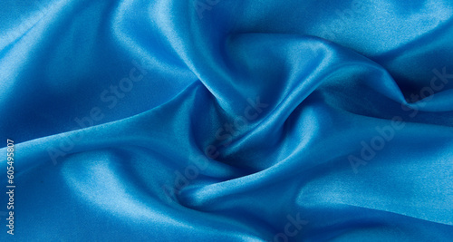 Abstract blue silk fabric texture background. Creases of satin 