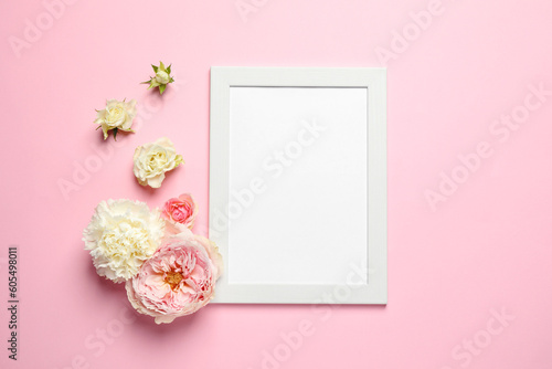 Empty photo frame and beautiful flowers on pink background, flat lay. Space for design © New Africa