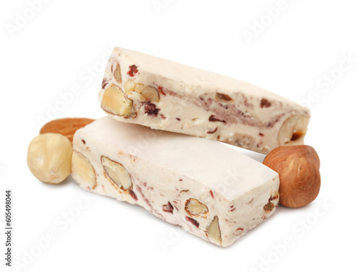 Pieces of delicious nougat and nuts on white background photo