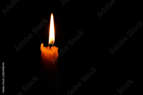 Burning candle on black background, closeup. Space for text
