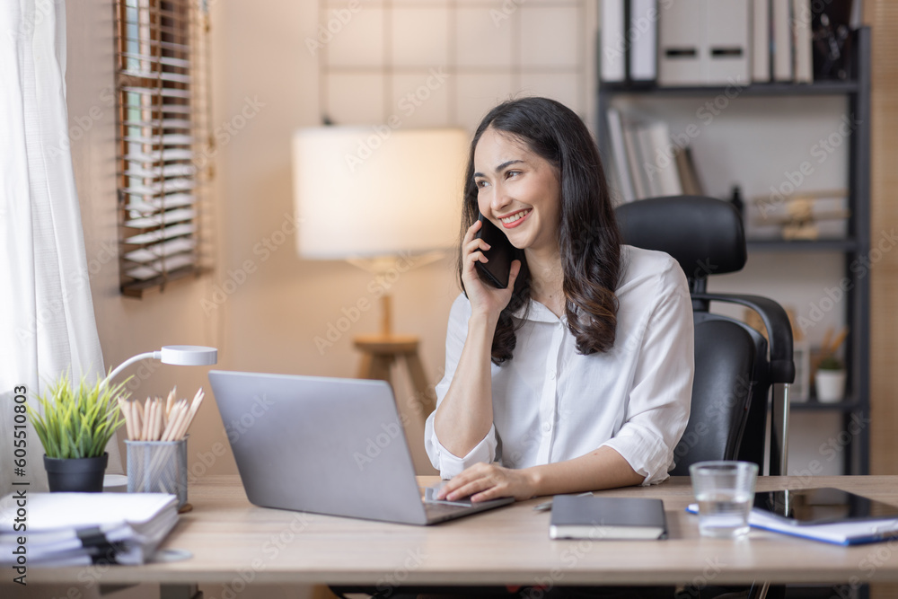 Happy caucasian young Asian woman using smart phone cellphone for calls, social media, mobile application online in office money financial planning Business And Education Concept. Happy caucasian young Asian woman using smart phone cellphone for calls, social media, mobile application online in office money financial planning Business And Education Concept.