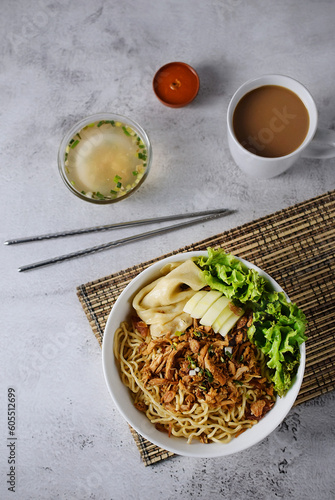 Mie ayam, noodles with chicken and vegetables, Indonesian traditional food in grey texture background.