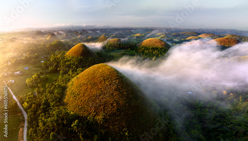 The Chocolate Hills are a geological formation in the Bohol province of the Philippines. They are covered in green grass that turns brown during the dry season, hence the name. photo