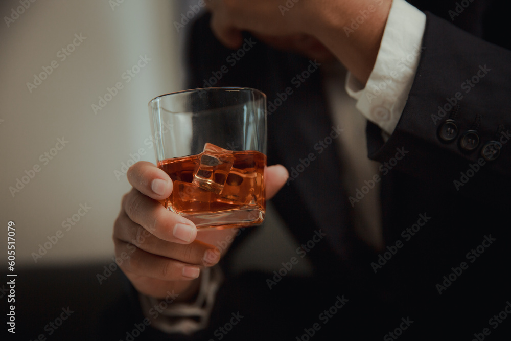 Businessman in black suit holding glass of whiskey Celebrate company success close-up Businessman in black suit holding glass of whiskey Celebrate company success close-up