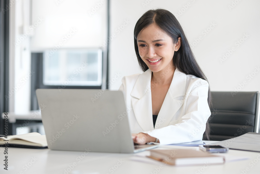 Professional female manager in stylish suit using laptop at her workplace. Professional female manager in stylish suit using laptop at her workplace.