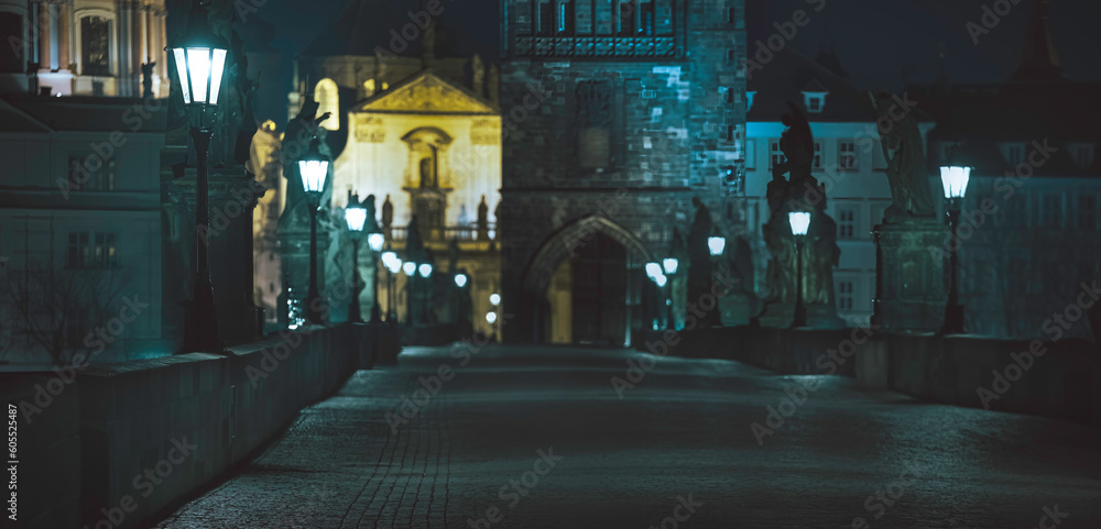 light from street lights and old statues on the krthel bridge at night in the center of Prague and 2021