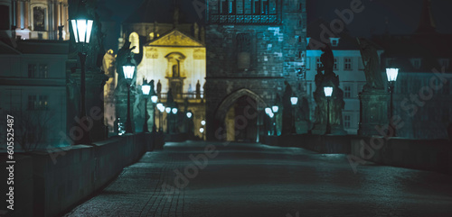 light from street lights and old statues on the krthel bridge at night in the center of Prague and 2021