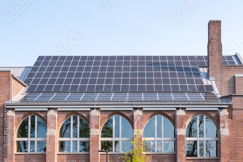 Older buildings going green to fight global warming: Solar panels generating electricity on the roof of a fully renovated church building. Shot in the Toronto Beaches.  Room for text.