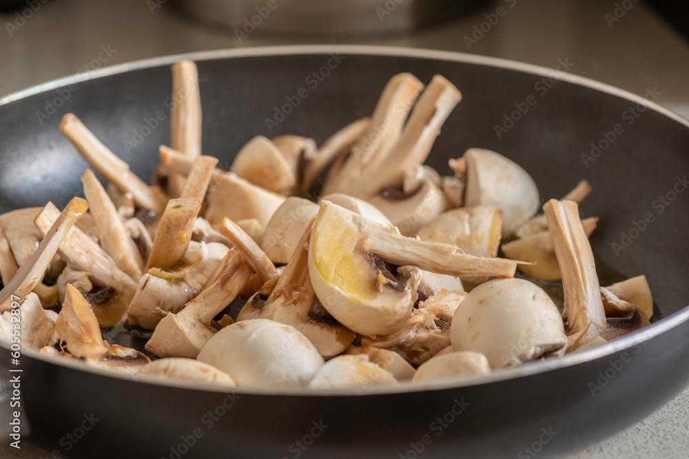 Chopped fresh mushrooms in a pan for further frying. Chopped fresh mushrooms in a pan for further frying.