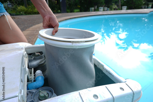 Obraz na plátne Female hand removing filter bag from  swimming pool filtration.