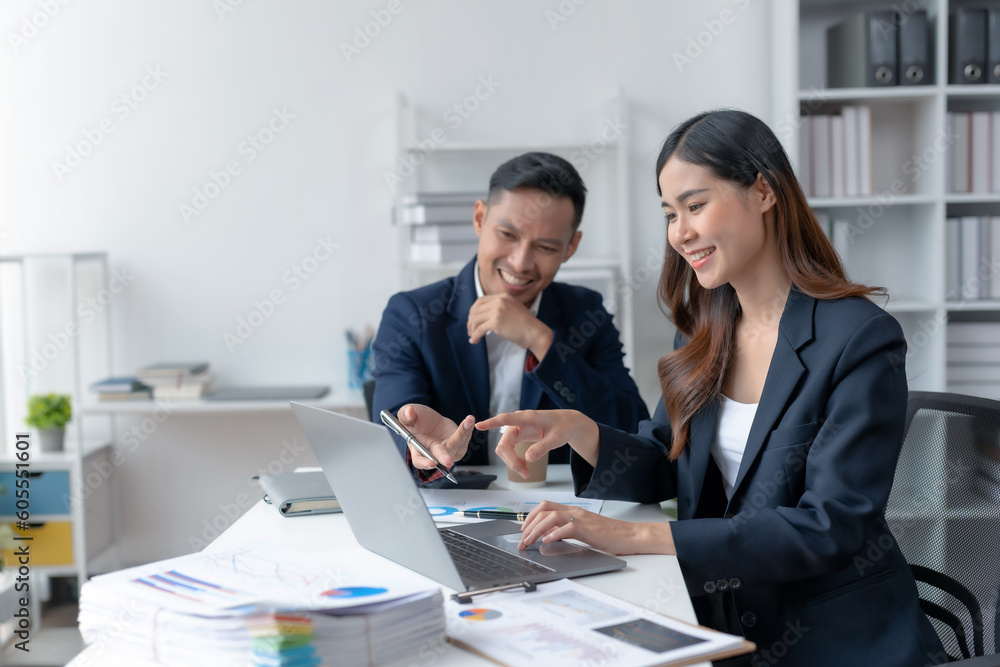 Asian businesswoman and businessman using laptop to discuss and consultation together at meeting. Collaboration of two Asian employees. Two people working in modern office. Asian businesswoman and businessman using laptop to discuss and consultation together at meeting. Collaboration of two Asian employees. Two people working in modern office.