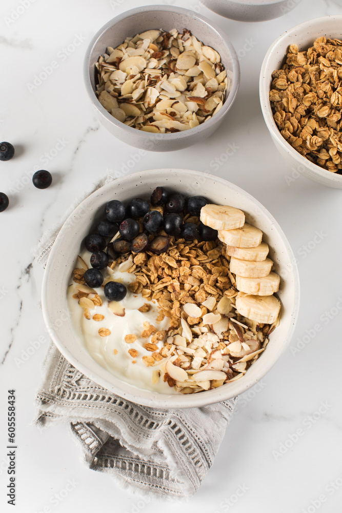 Homemade granola with Greek yogurt, almonds, blueberries and banana in a bowl. Homemade granola with Greek yogurt, almonds, blueberries and banana in a bowl.