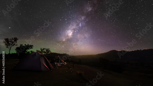 Hiking gray tent camping with light sky and galaxy milky way on high mountain night sceenon sky of Thailand, Long exposure photograph, with grain noise.
