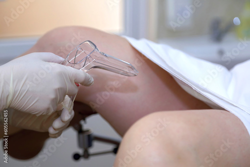 The gynecologist takes a vaginal swab for bacterial examination. Gynecological chair. A woman at the gynecologist for a check-up. photo