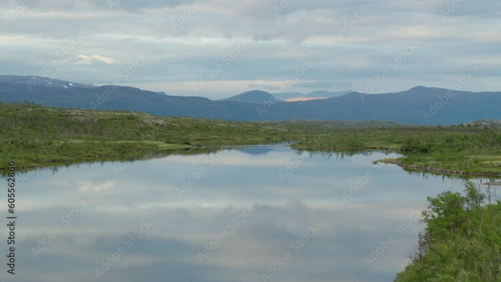 Still lake reflecting cloudy sky by Swedish mountains, aerial push-in Still lake reflecting cloudy sky by Swedish mountains, aerial push-in