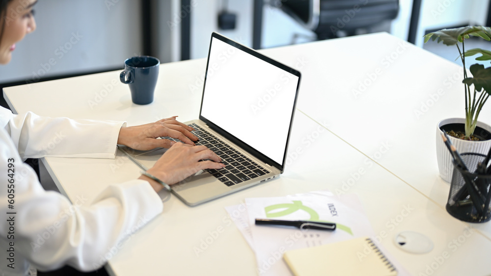 A female office worker using her laptop computer at her desk. laptop mockup A female office worker using her laptop computer at her desk. laptop mockup