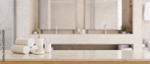 Copy space on a white tabletop with toiletries in a modern white bathroom with double sink.