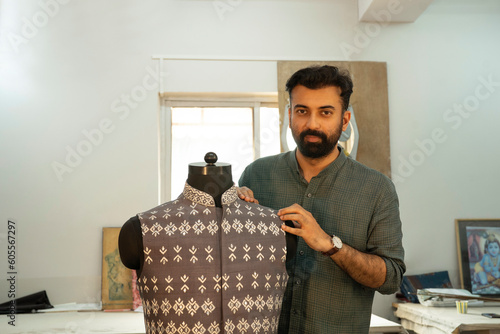 menswear designer working on a bespoke Nehru jacket in his studio 