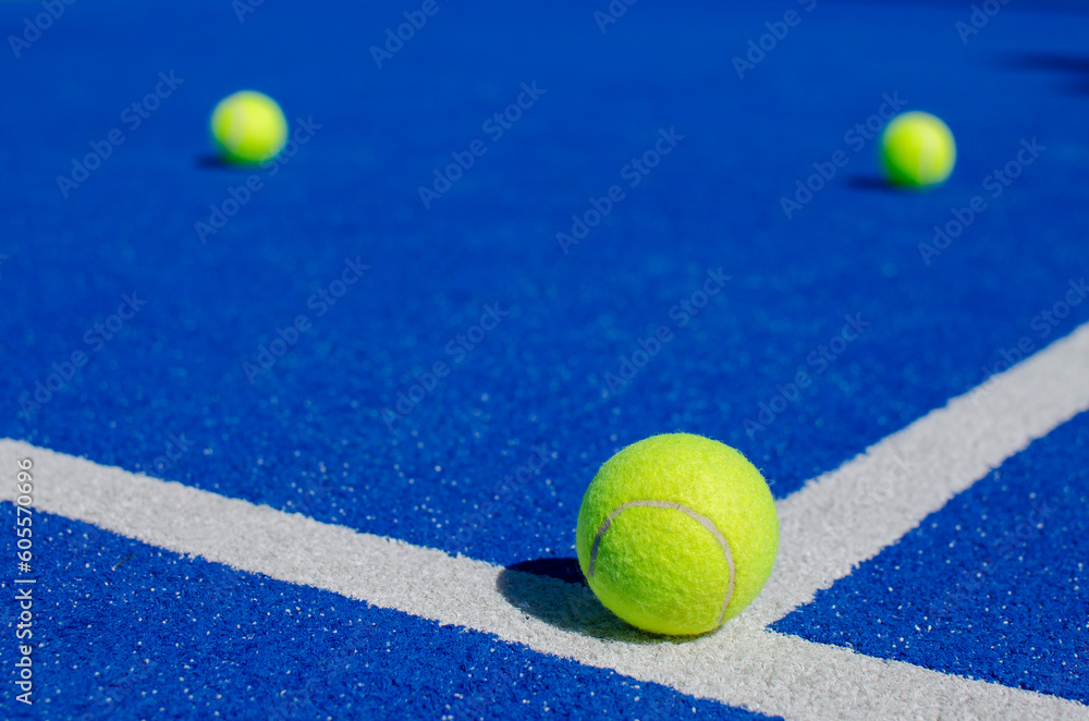 selective focus, three balls on a blue paddle tennis court, racket sports concept