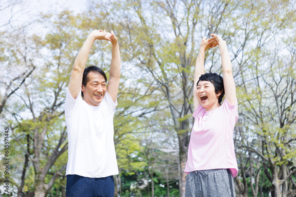 Fototapeta premium 公園で伸びる成熟した日本のカップル