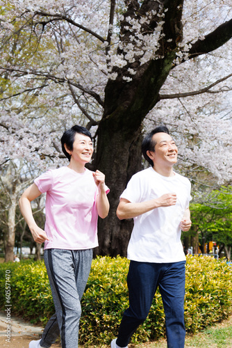 公園でジョギングするスポーツウェアの成熟した日本のカップル