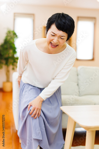 家で膝の痛みに苦しんでいる成熟した日本人女性
