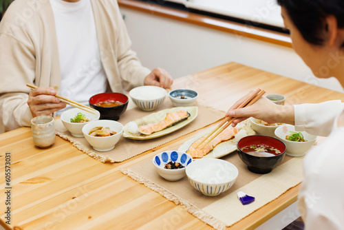 ダイニングテーブルに日本の食べ物を持っている2人 photo