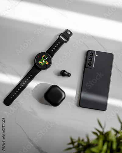 Smartwatch, earbuds and pone on marble table  photo