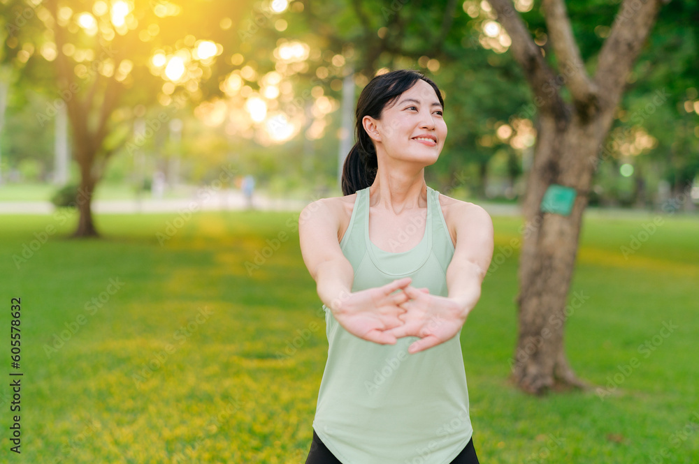 Female jogger. Fit young Asian woman with green sportswear stretching muscle in park before running and enjoying a healthy outdoor. Fitness runner girl in public park. Wellness being concept Female jogger. Fit young Asian woman with green sportswear stretching muscle in park before running and enjoying a healthy outdoor. Fitness runner girl in public park. Wellness being concept