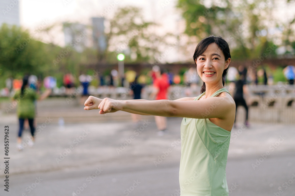 Female jogger. Fit young Asian woman with green sportswear aerobics dance exercise in park and enjoying a healthy outdoor. Fitness runner girl in public park. Wellness being concept Female jogger. Fit young Asian woman with green sportswear aerobics dance exercise in park and enjoying a healthy outdoor. Fitness runner girl in public park. Wellness being concept