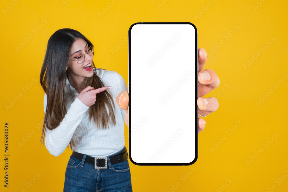 Holding big blank cell phone, cheerful caucasian woman holding big blank cell phone. Millennial lady pointing finger smartphone mockup. Recommending new application, mobile website, online shopping. - obrazy, fototapety, plakaty 