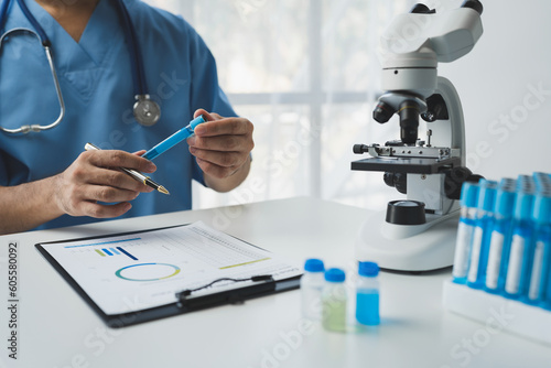 Medical or scientific researchers analyzing and discussing test tubes of laboratory solutions for biological diagnosis and research. operational concepts, health insurance.
