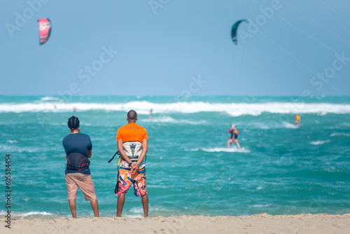 Active sporty people enjoying kitesurfing holidays and activities on perfect sunny day on Cabarete tropical sandy beach in Dominican Republic