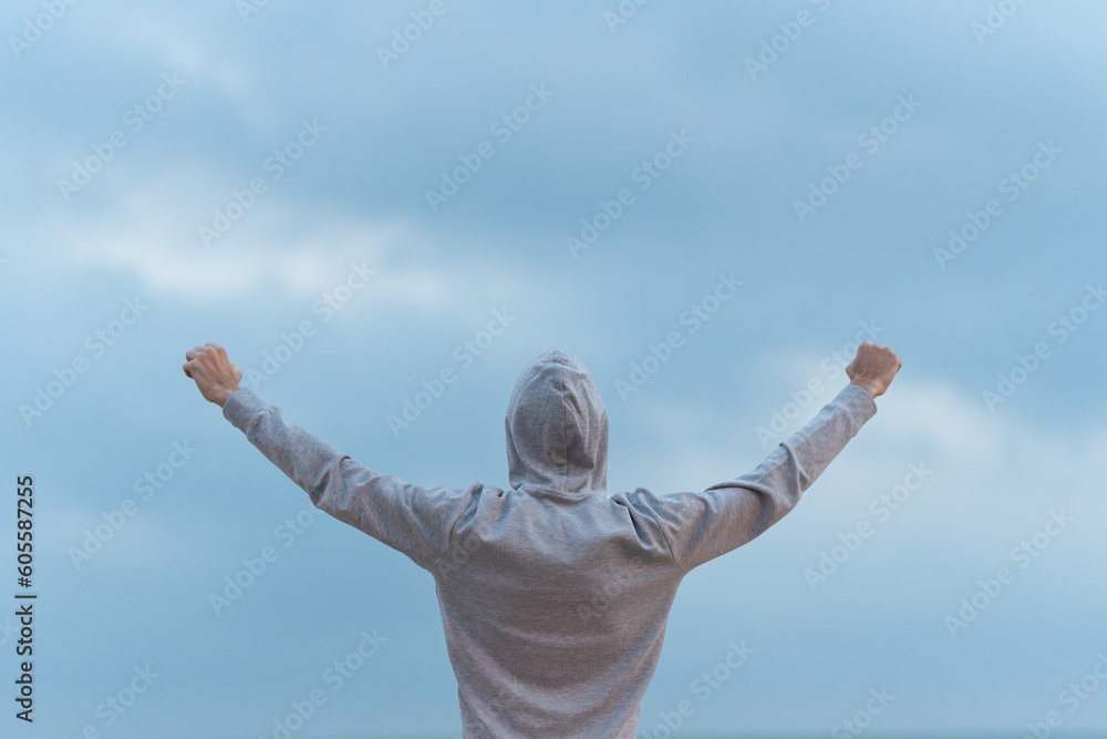 Rear view of man outstretching arms to sky Rear view of man outstretching arms to sky