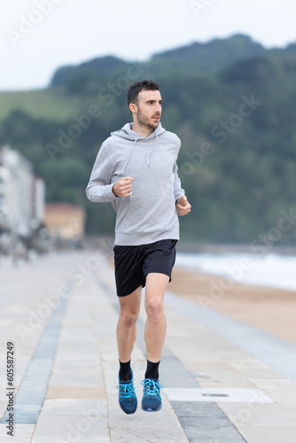 Young man running outdoors wearing a hoodie