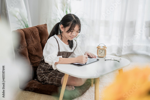A young girls use laptop computers and tablets to find educational information at home. online home study concept