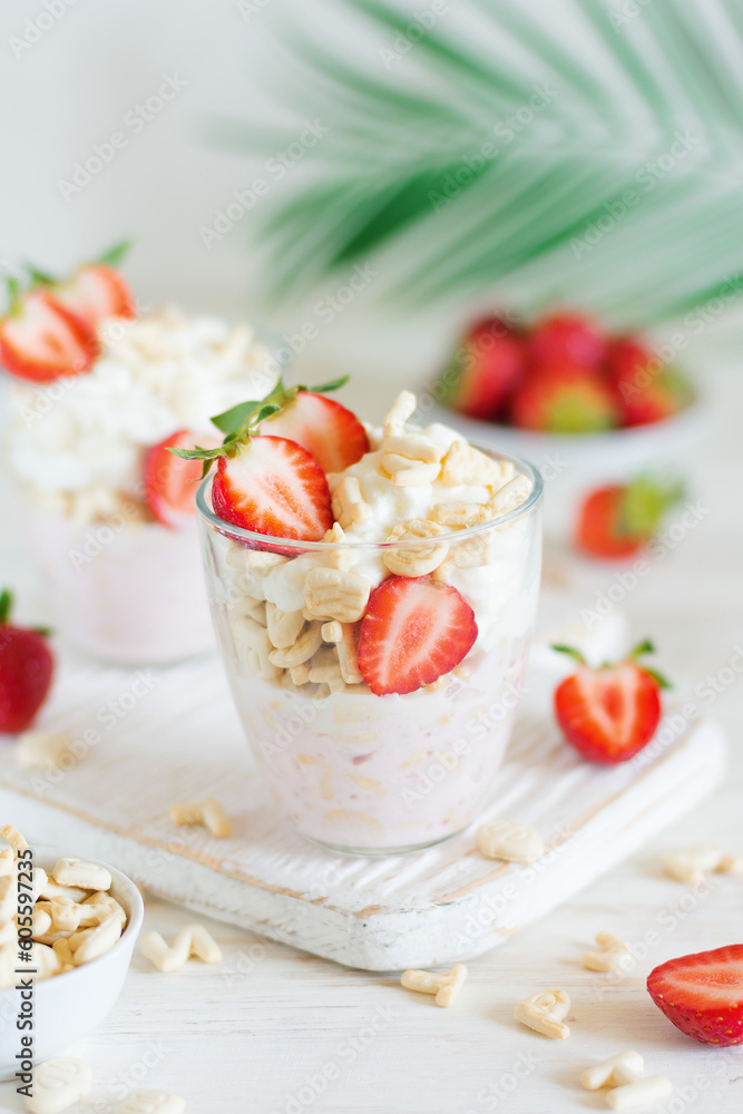 Desserts of cookies and whipped cream with strawberries in glasses, close-up, background in blur. Desserts of cookies and whipped cream with strawberries in glasses, close-up, background in blur.