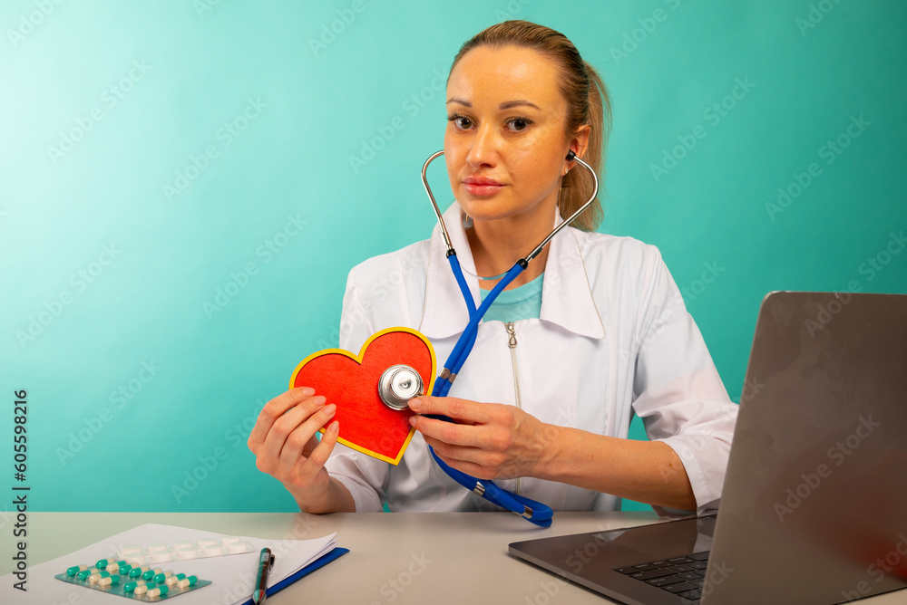 Cardiologist holding heart model and stethoscope in his office, heart attack concept. Cardiologist holding heart model and stethoscope in his office, heart attack concept.