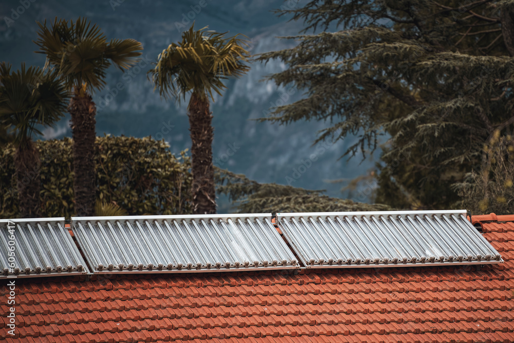 Water solar collector on a red metal roof. Solar thermal and solar ...