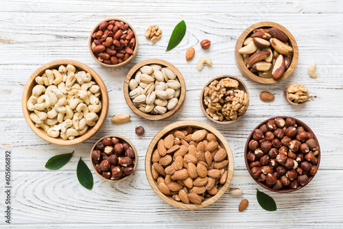 mixed nuts in wooden bowl. Mix of various nuts on colored background. pistachios, cashews, walnuts, hazelnuts, peanuts and brazil nuts