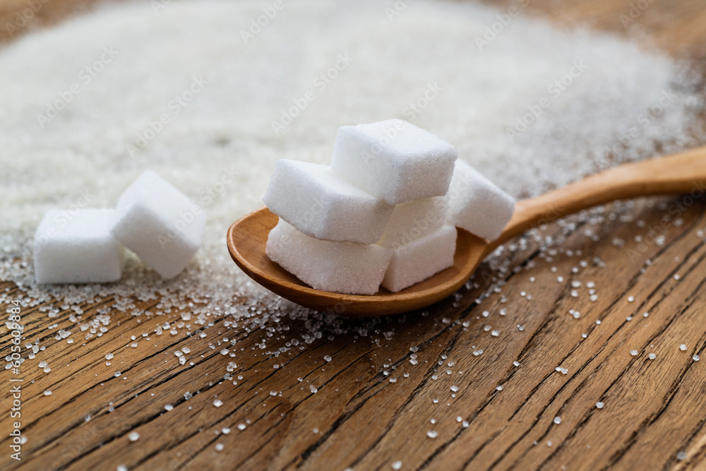 Spoon with sugar cubes on top of granulated sugar Spoon with sugar cubes on top of granulated sugar