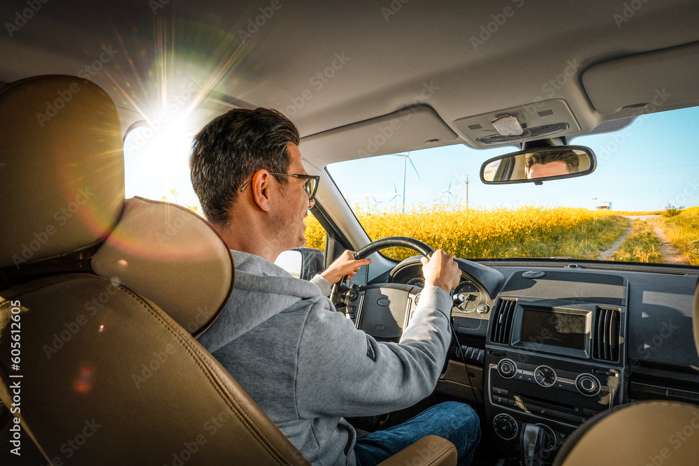 man driving a car in yellow field man driving a car in yellow field