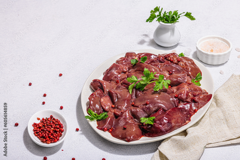 Raw chicken liver on stone background. Fresh ingredients ready for cooking, parsley, red pepper Raw chicken liver on stone background. Fresh ingredients ready for cooking, parsley, red pepper