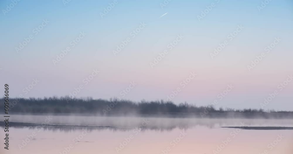Morning mist over a lake surrounded by grass and bushes at dawn Morning mist over a lake surrounded by grass and bushes at dawn