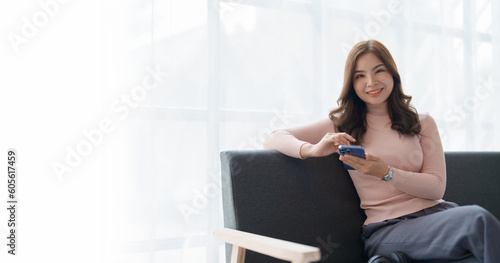 Home lifestyle woman relaxing sleeping on sofa patio living room. Happy lady sitting on comfortable sofa using smartphone mobile while select listen music Tropical vacation.