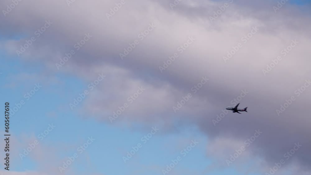 Wide shot of an the airplane flies through the blue sky with white clouds Wide shot of an the airplane flies through the blue sky with white clouds