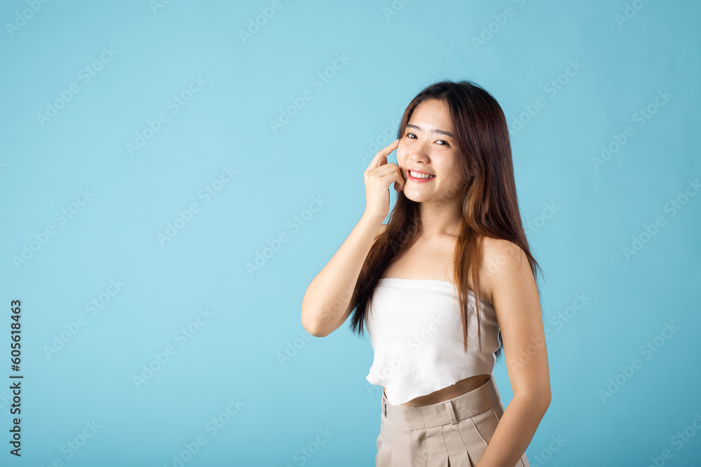 Beauty and Skin care. Asian woman with beauty face touching healthy facial clean skin studio shot isolated on blue background, Beautiful female model smiling with natural makeup and healthy face Beauty and Skin care. Asian woman with beauty face touching healthy facial clean skin studio shot isolated on blue background, Beautiful female model smiling with natural makeup and healthy face