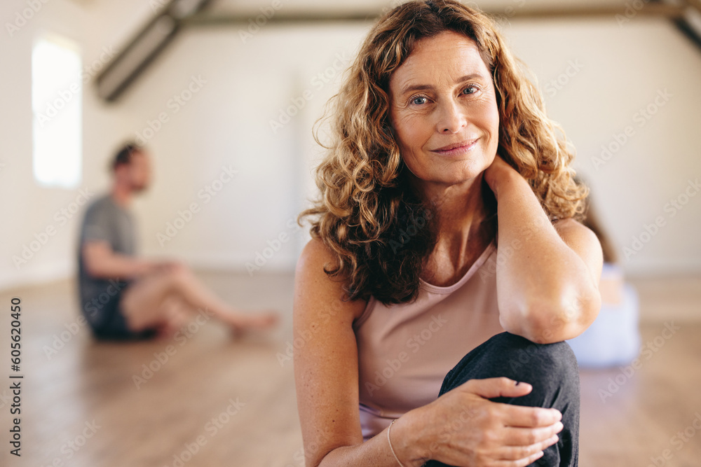 Portrait of a senior woman sitting in a yoga studio - obrazy, fototapety, plakaty 