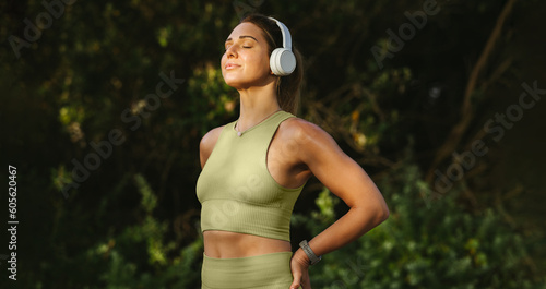 Fotografija Woman listening to music and doing a breathing exercise outdoors