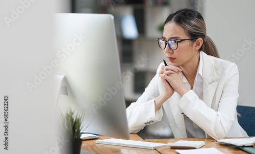 Photography Beautiful business lady looking seriously watching on desktop monitor screen, sitting in modern office